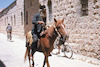 תושב ממוצא תימני רוכב על סוס בשכונת נחלאות, סמוך למחנה יהודה בירושלים – הספרייה הלאומית