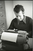 פורטרט של הסופר אריה חשביה מקליד במכונת כתיבה – הספרייה הלאומית