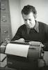 פורטרט של הסופר אריה חשביה מקליד במכונת כתיבה – הספרייה הלאומית