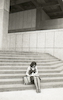 אשה יושבת על מדרגות בית התפוצות באוניברסיטת תל אביב.