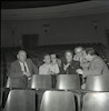 לאה גולדברג ואחרים יושבים באולם.