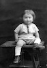 הילד נחמיה שיין (בן בתיה ואליעזר שיין) יושב על כיסא, תצלום סטודיו.