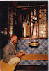 יהודי בלבוש מסורתי יושב ליד ארון הקודש ומתפלל, בית הכנסת 'אלגריבה', ג'רבה, תוניסיה.