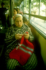 A woman knitting while sitting in a bus.