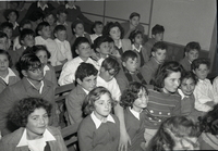 ילדים יושבים באסיפה של כפר הנוער של עליית הנוער ע"ש ישראל גולדשטיין