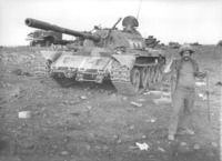 פנדריך ליד טנק סורי-רוסי שנורה, מאחורה רואים עוד ציוד סורי הרוס.