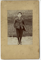 Photograph of young teen, Wolf “William” Baum, outdoors with books under his arm (late 19th century).