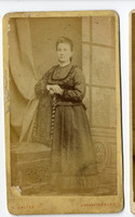 Portrait of a woman standing behind a chair (late 19th Century).