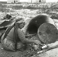 אשה אופה בטבון בחצר.