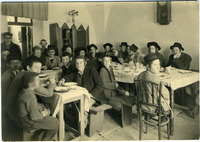 נערים בני היישוב הישן יושבים לאכול במסיבה.