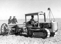 טרקטוריסט ליד הגה ושני בחורים מאחור בפעולת זריעה, 2 מתוך 2.