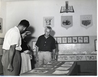 רחל ינאית בן-צבי, רעיית נשיא המדינה צופה בתערוכה של "מגן דוד ירוק", רחובות, 1 מתוך 2.