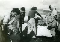 קבוצת נשים עובדות בחוץ עם בדים.