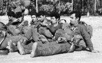 Four sons parachuting while their parents look with mixed anxiety and pride.