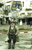 With his right hand raised and wearing his now familiar trilby hat, the Lubavitcher Rebbe looks down benignly on passers-by from many of the illuminated signs that can be seen on many street corners of Israeli towns.