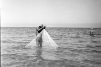 A seashore fisherman trowing his net.