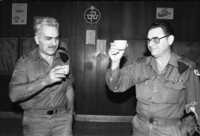 אלוף שלמה גזית, ראש אמ"ן היוצא, מרים כוסית לחיי יורשו, אלוף יהושע שגיא, בטקס חילופי התפקידים בקנטינה של בסיס צבאי.