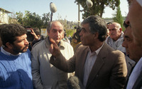 קבוצת גברים משוחחים בחוץ, עם ציוד צילום.