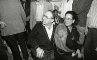 זוג יושב מוקף באנשים.