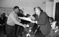 Labour Minister Josef Akmogi presents a certificate to a Gaza man on completion of a surveyors course organized by the Ministry.