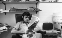 Pressphotographer Shmuel Rachmani reding a newspaper in the office.