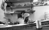Pressphotographer Shmuel Rachmani reding a newspaper in the office.