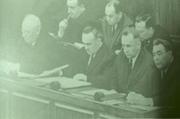 קבוצת גברים יושבים סביב שולחן בישיבה.