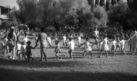 בחג השבועות ילדים רוקדים על הדשא המרכזי.